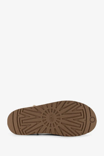 Brown rubber sole with ugg logo and distinctive tread pattern on ugg women’s beige nubuck sandals back side