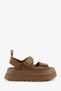 Ugg women’s brown rubber platform sandal with thick sole and adjustable velcro straps shown from the back side