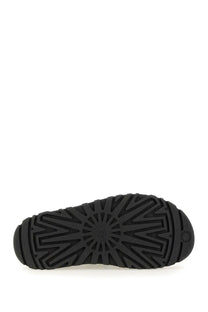 Back view of ugg women’s sandal goldenglow black with black rubber sole and radiating tread pattern embossed with ugg logo