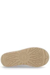 Beige rubber sole with radiating tread pattern and ugg logo on the back side of ugg women’s tasman white shoe