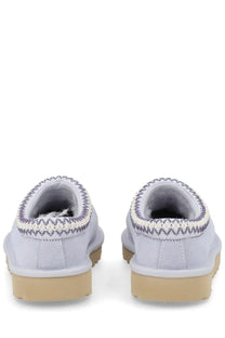 Ugg women’s light gray suede Tasman slip-on mules with white and dark gray zigzag stitching along the collar