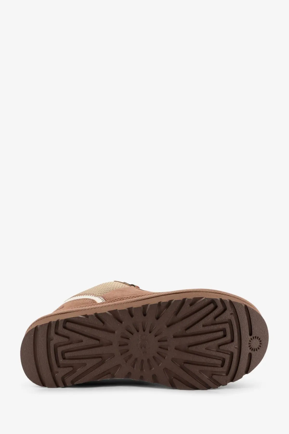 Brown ugg boot with suede upper and rubber sole featuring uggs signature starburst tread pattern