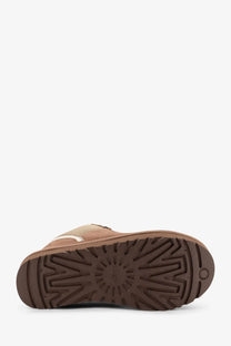 Brown ugg boot with suede upper and rubber sole featuring uggs signature starburst tread pattern