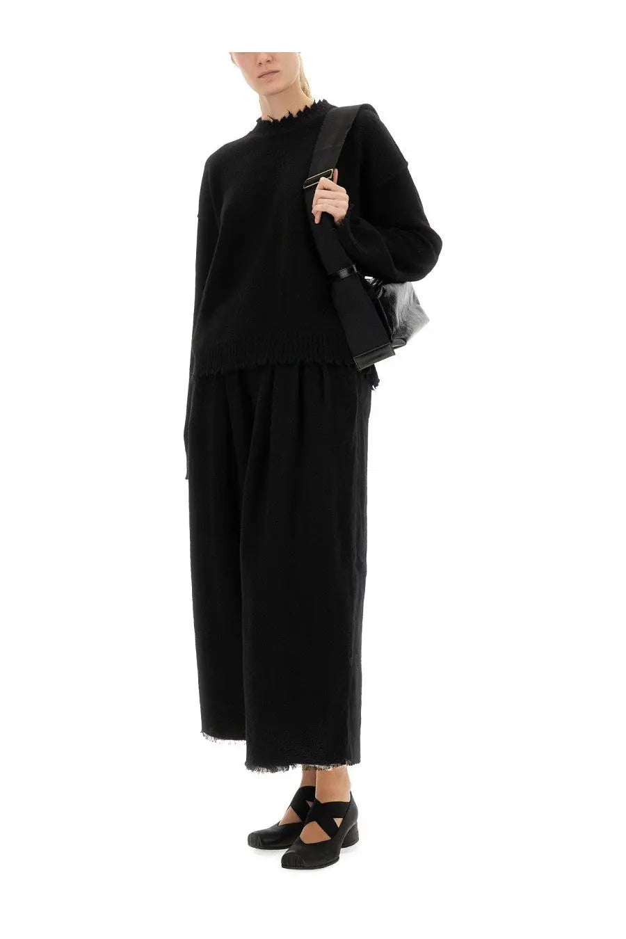 Black uma wang shoulder bag with sleek minimalist design and subtle metallic hardware accents complements cashmere sweater