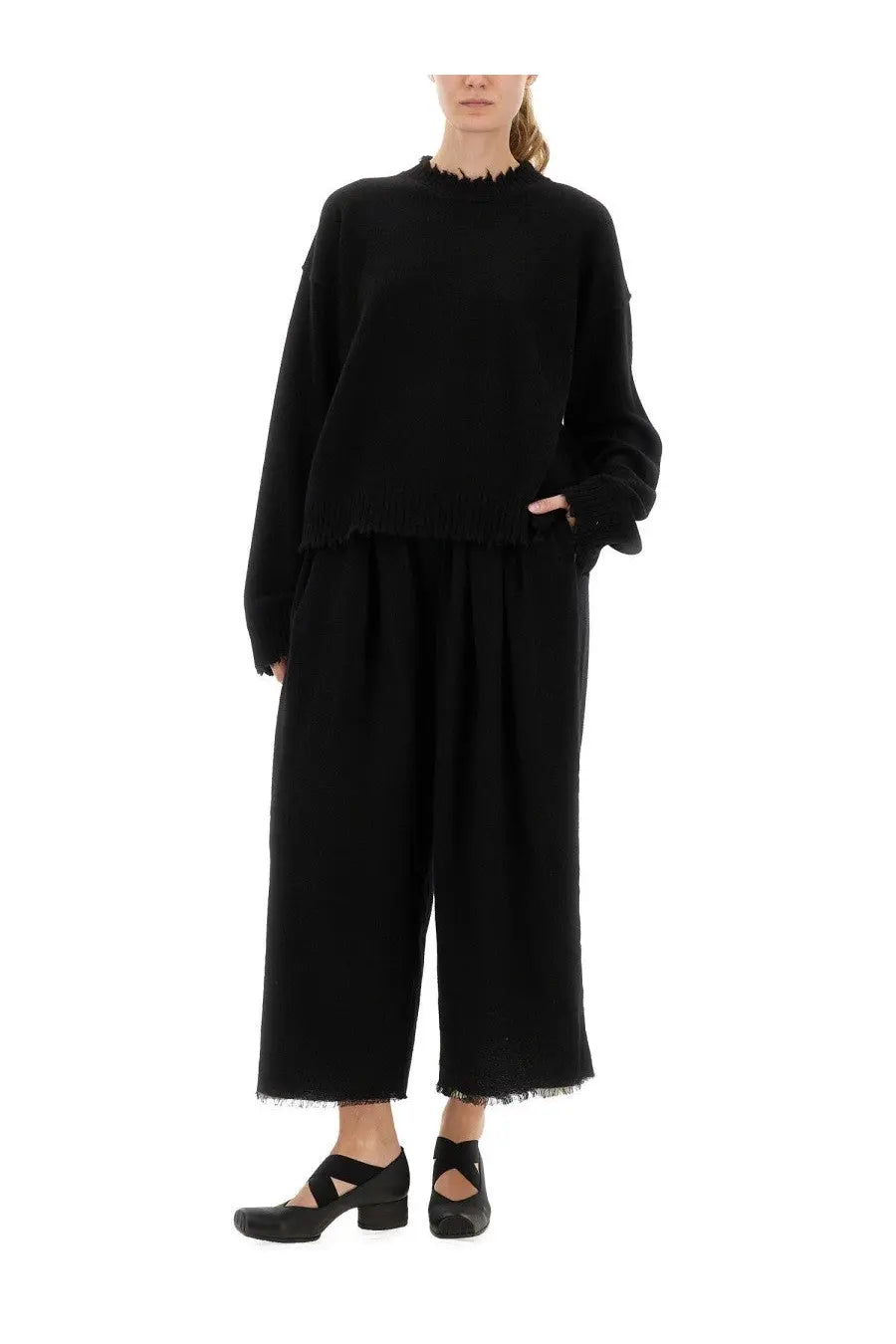 Black oversized knit sweater with frayed hem and cuffs paired with uma wang women’s pants poetic black wide-leg trousers