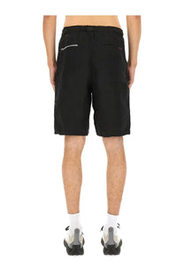 Undercover men’s linen shorts black showing back side with drawstring waistband and silver zipper detail on pocket
