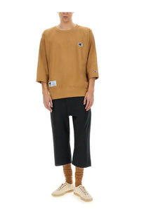 Tan unisex champion sweatshirt with three-quarter sleeves and embroidered logo on chest in beige fabric