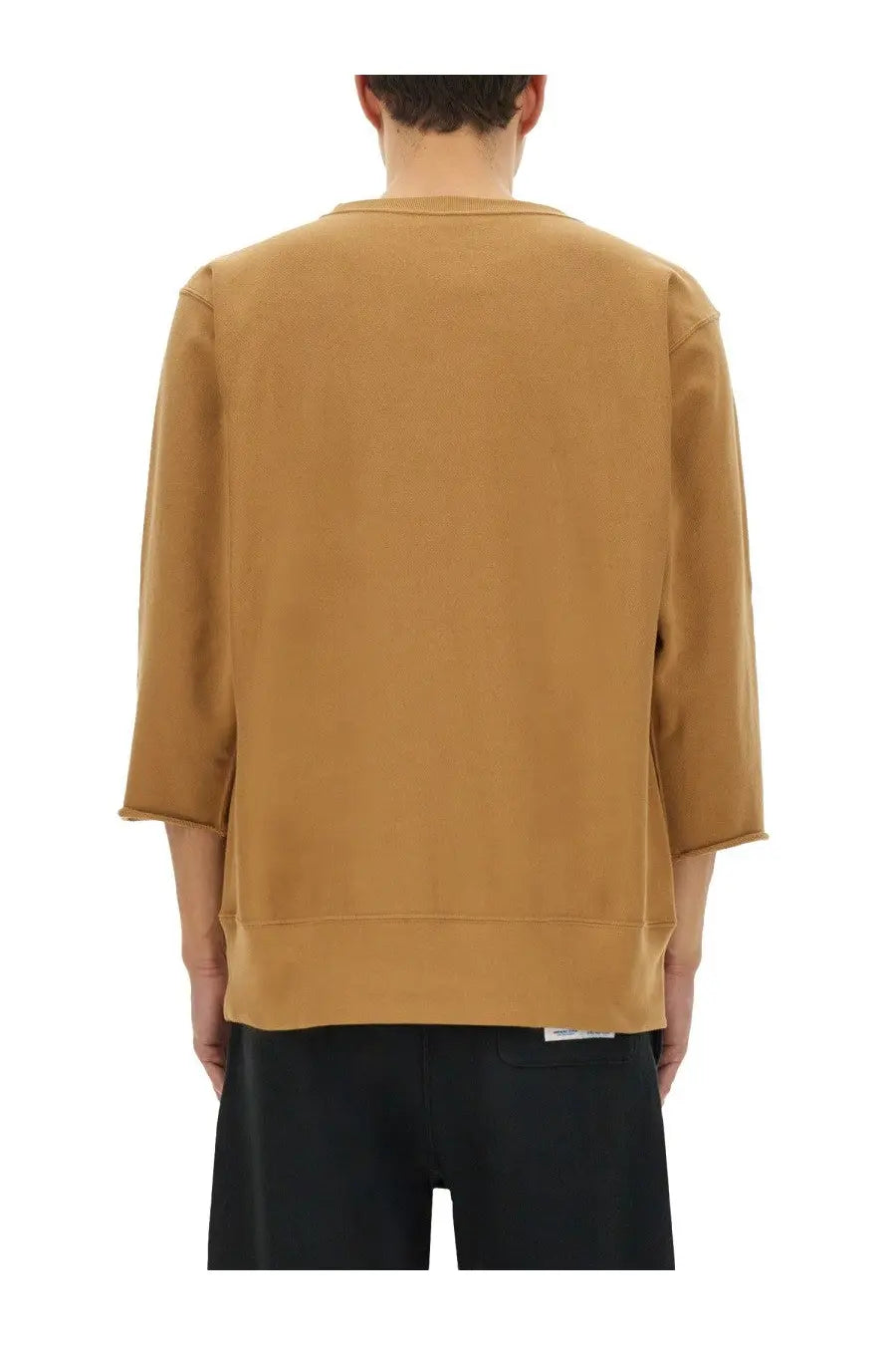 A tan undercover unisex champion sweatshirt with relaxed fit three-quarter sleeves and ribbed cuffs