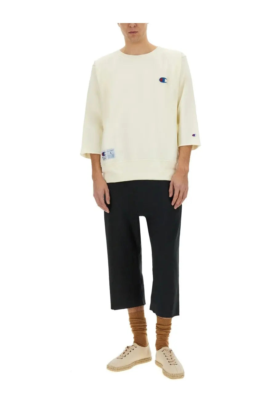 Cream-colored unisex champion sweatshirt with classic logo patches on chest and sleeve from undercover white collection