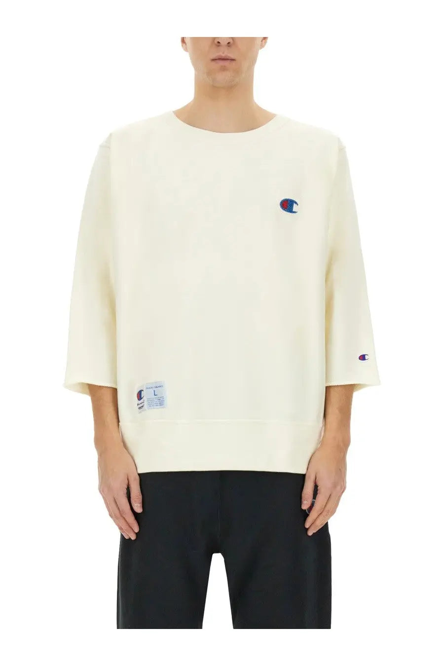 Cream-colored unisex champion sweatshirt with embroidered logo on chest and sleeve featuring relaxed fit