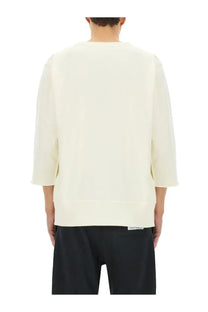 Cream-colored unisex under armour sweatshirt with three-quarter sleeves ribbed cuffs and a relaxed fit
