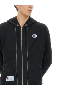 Undercover unisex black champion hoodie with red and blue embroidered logo, full-length zipper, and front pockets
