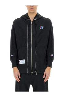 Black champion zip-up hoodie with silver zippers and embroidered logos from undercover unisex sweatshirt collection