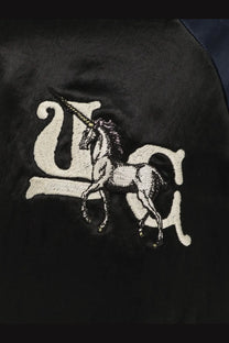 Undercover women’s black satin bomber jacket with detailed white embroidered unicorn logo and stylized usa lettering