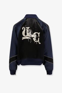 Navy blue satin Undercover women’s bomber jacket showing the back with white embroidered unicorn and ua lettering