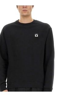 Valentino men’s black cotton crewneck sweatshirt with a small white logo patch on the left chest