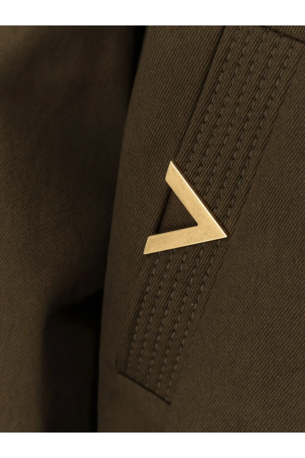 Gold-tone triangular pin on dark brown textured fabric of valentino men’s cotton green jacket