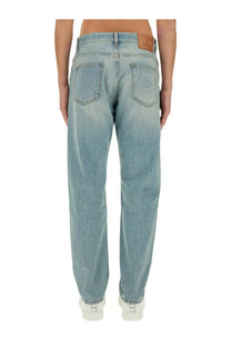 Valentino men’s light-wash denim pants with a relaxed straight-leg cut and brown leather patch at the waistband