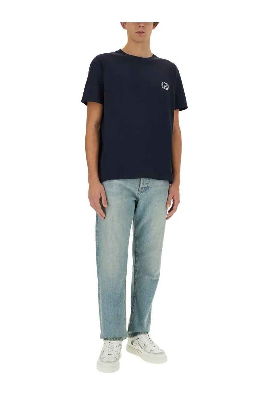 Navy blue short-sleeved t-shirt with small white embroidered logo on left chest paired with valentino men’s denim pants blue