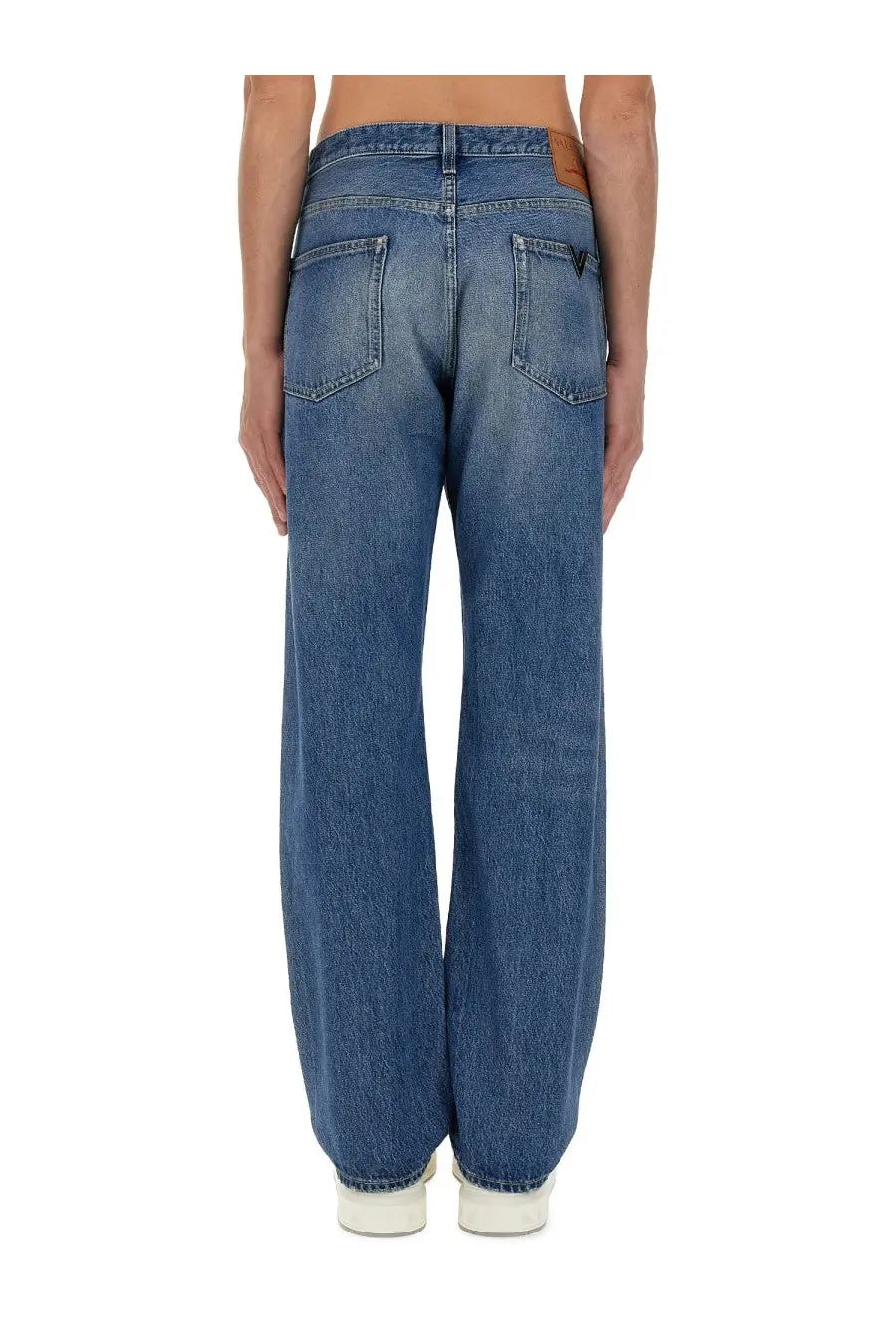 Back side of Valentino men’s blue denim jeans with faded wash and classic back pockets