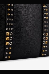 Valentino men’s black leather shoulder bag with gold and silver-toned studs arranged in vertical rows along the sides
