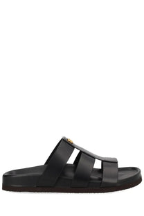 Valentino men’s sandalo slide studshield black leather sandal with gold-tone circular logo on the strap