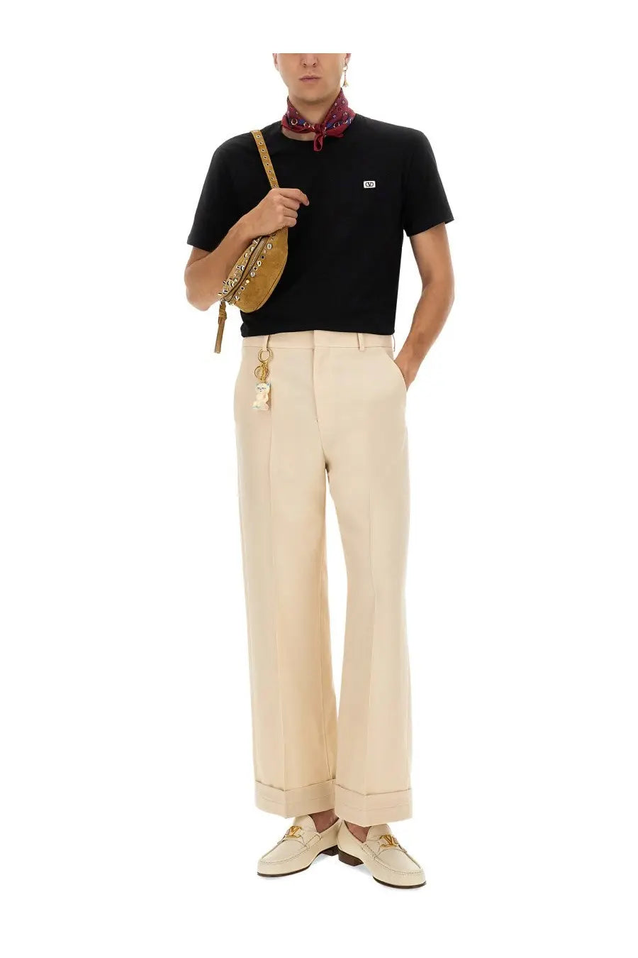 Tan leather crossbody bag with gold-tone hardware and chain strap paired with valentino men’s black shirt
