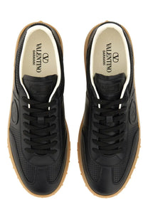 Valentino men’s upvillage sneaker black leather with tan rubber soles and white laces shown from the back side
