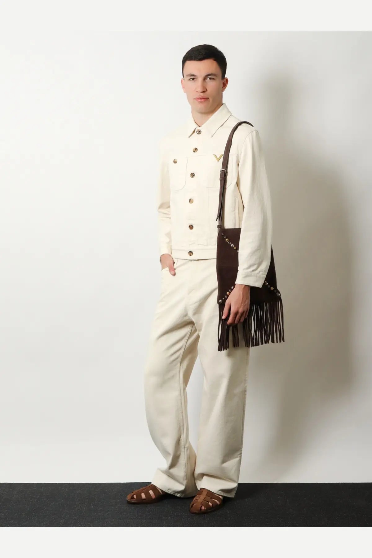 Brown suede fringed shoulder bag with metallic studs complementing valentino men’s white denim jacket white