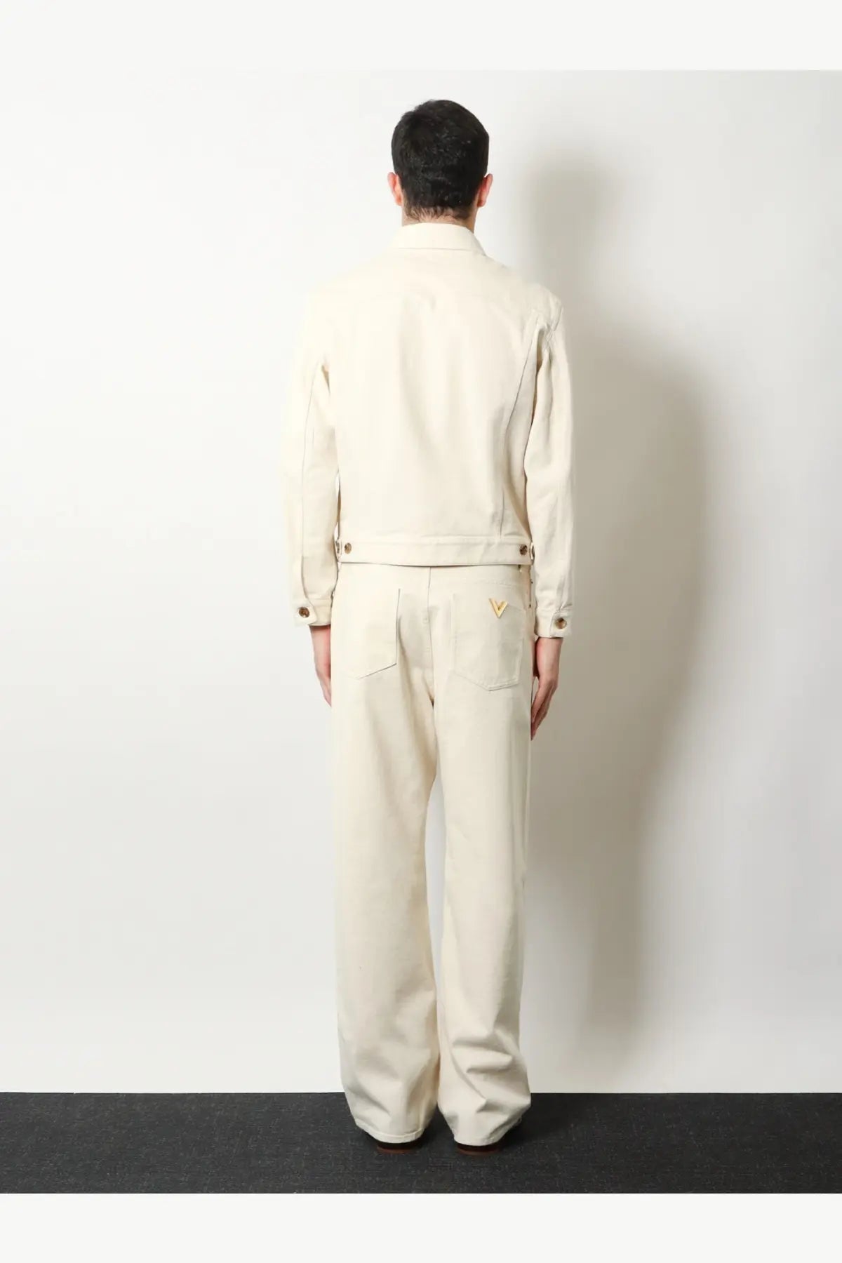 Valentino men’s white cream-colored denim jacket with gold-tone buttons and embroidered logo on back pocket shown from back