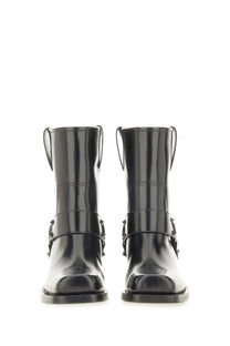 Valentino women’s black patent leather ankle boots with glossy finish and decorative metal buckles