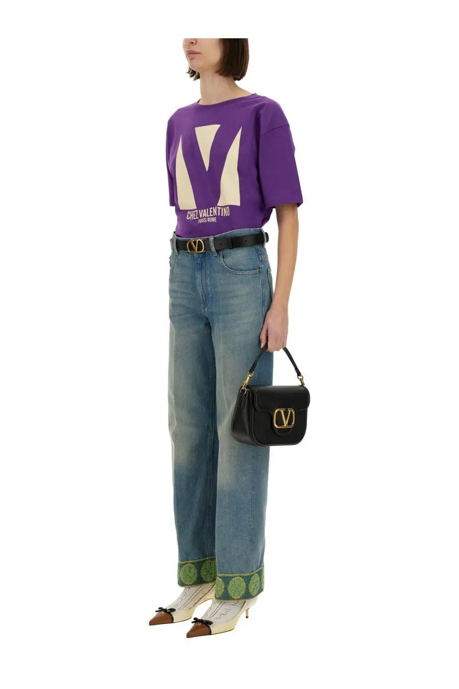 Black leather Valentino handbag with gold-tone logo clasp paired with purple chez Valentino print shirt for women