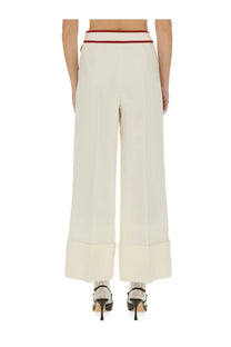 Valentino women’s cream crepe wide-leg trousers with red-trimmed waistband and rolled cuffs