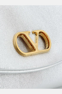 Gold-tone valentino logo clasp on silver textured laminated leather valentino women’s devain shoulder bag
