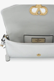 Light gray leather Valentino Garavani clutch with gold-tone hardware and signature logo clasp in silver finish
