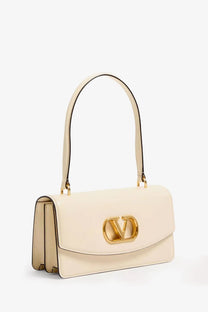 Cream-colored leather Valentino women’s Vlogo shoulder bag with gold-tone logo clasp and matching handle in white