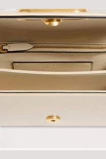 Cream-colored leather Valentino women’s Vlogo shoulder bag with gold-tone hardware and zippered interior compartment