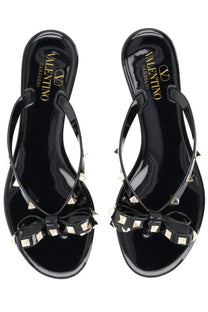 Valentino women’s black glossy leather Rockstud sandals with gold-tone pyramid studs and bow detail flip-flops