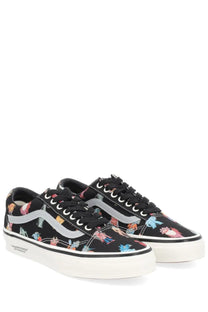 Vans men’s sneaker old skool in black with colorful cartoon dinosaur print silver side stripe and white rubber sole