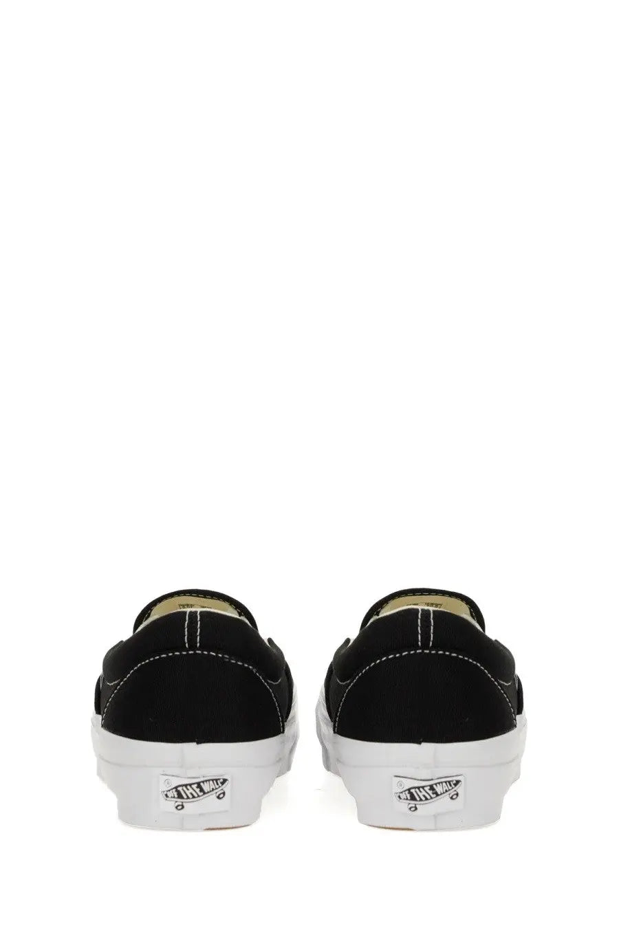 Back side of black canvas vans unisex slip on premium sneaker with white rubber sole and classic vans logo on heel