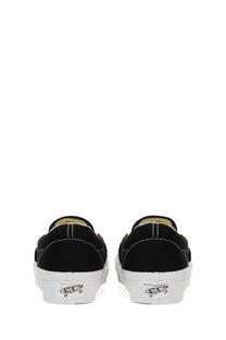 Back side of black canvas vans unisex slip on premium sneaker with white rubber sole and classic vans logo on heel
