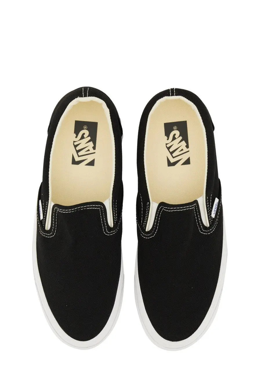 Black vans unisex slip on premium sneaker featuring black slip-on canvas with white rubber soles and contrasting stitching