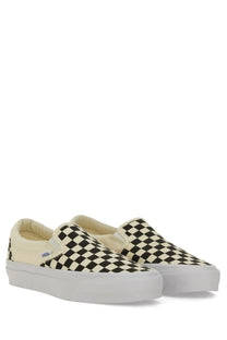 Vans unisex slip on premium white sneakers with black and cream checkerboard pattern and white rubber sole