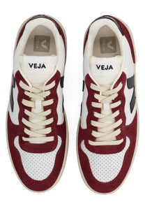 Maroon and white suede sneakers with perforated toe panels, black side stripes, and cream laces.