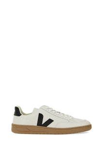 Veja men’s white leather sneaker with bold black V logo, tan rubber sole, and black heel tab