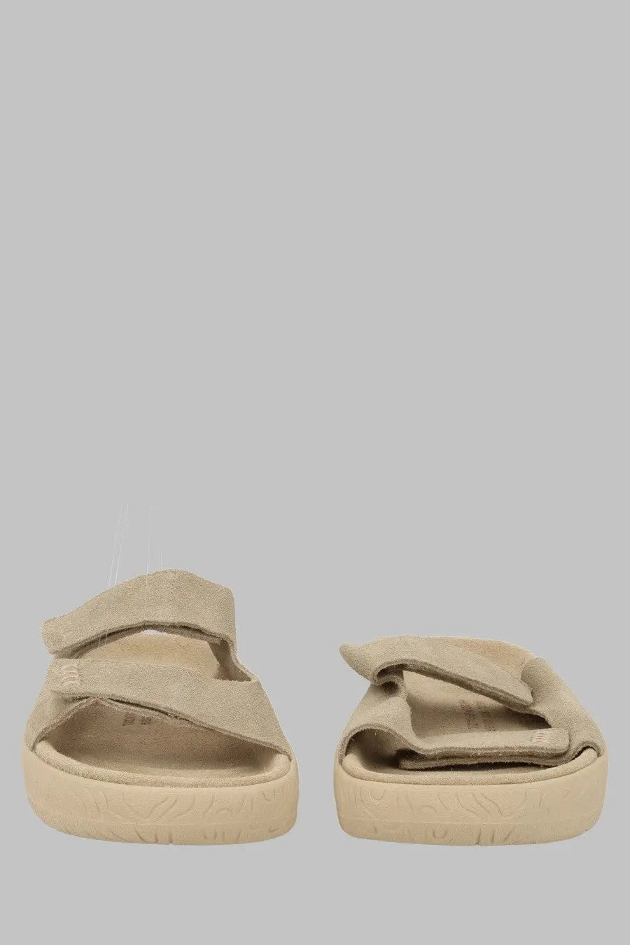 Beige suede slide sandals by Veja with two adjustable velcro straps and a chunky rubber sole for unisex wear