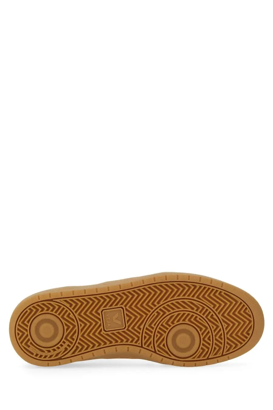 The sole of a tan rubber veja unisex sneaker showing a herringbone tread pattern with circular design elements