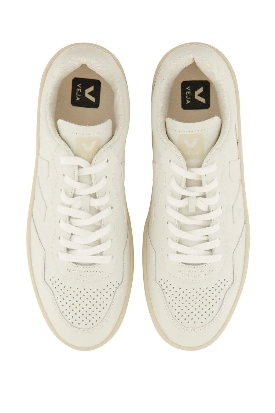 Pair of veja unisex white sneakers with perforated toe box and matching laces in durable leather material