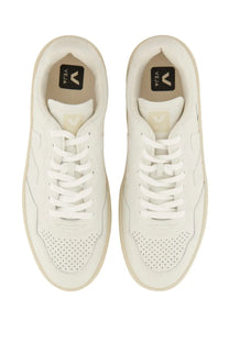 Pair of veja unisex white sneakers with perforated toe box and matching laces in durable leather material