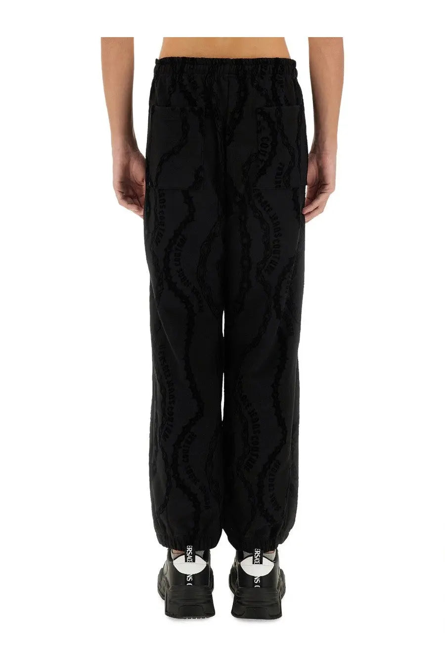 Black textured Versace Jeans Couture men’s joggers with raised paris lettering all over for casual wear